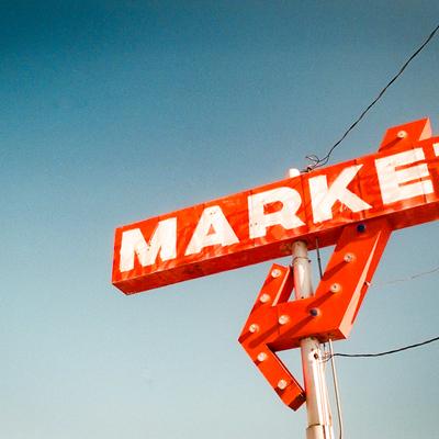 Market sign against blue sky